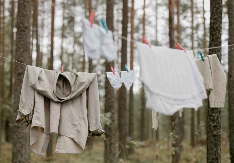 Clothes hanging on a line in a serene forest, creating a rustic outdoor laundry scene.